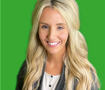 Employee with blonde hair in front of green background