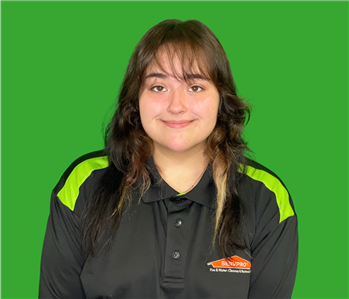 employee with black shirt and hair by a green background